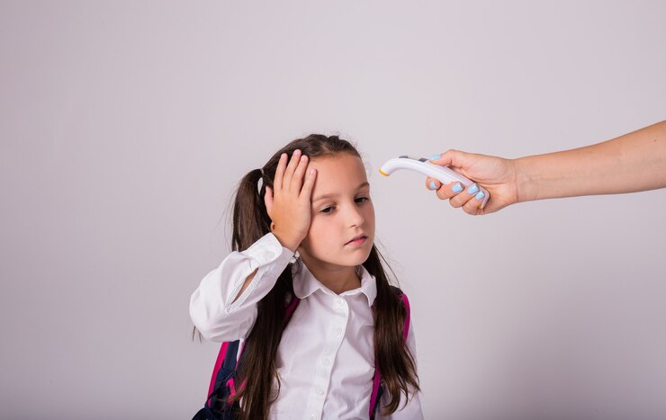 sick-schoolgirl-uniform-with-backpack-measures-temperature-with-infrared-thermometer-white-background-with-place-text_208700-3038
